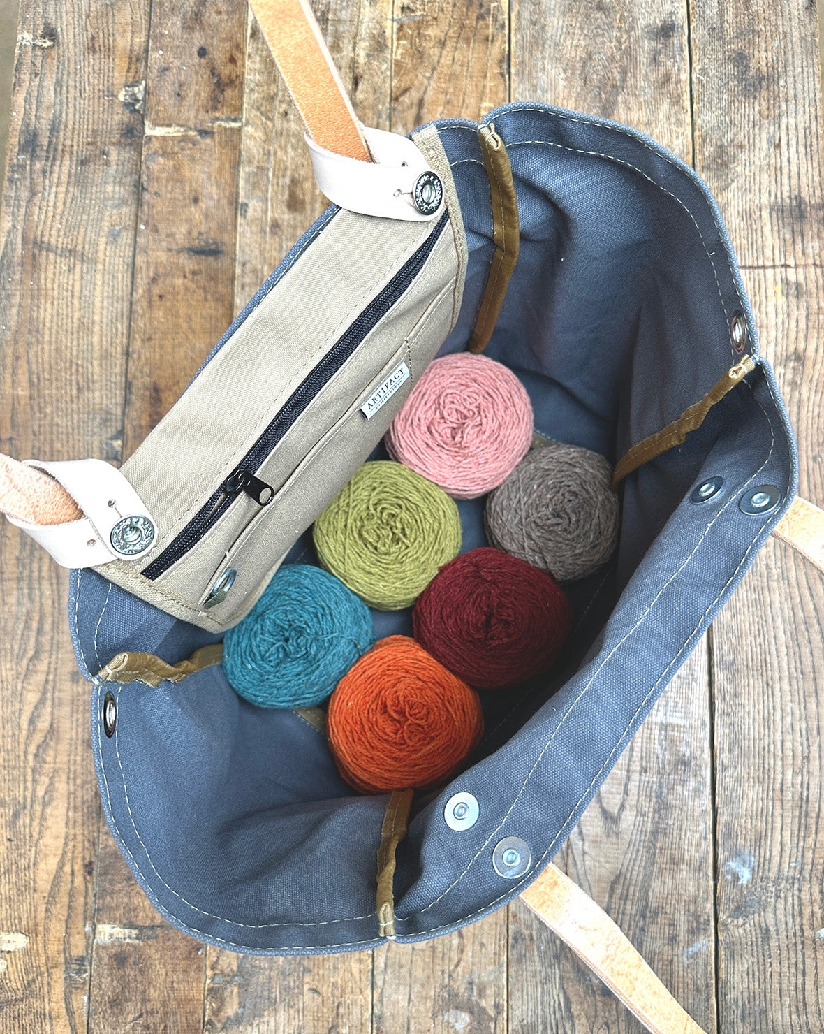 Artifact knitting tote bag shown open with yarn cakes inside, tote insert not included