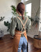Person modeling a cross-back strap copper ceramics potter apron in a studio. 
